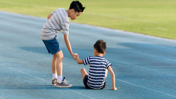 boy helping another boy, teach empathy to kids