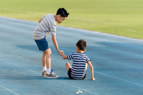 boy helping another boy, teach empathy to kids